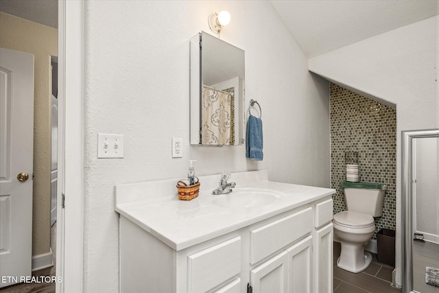 bathroom featuring vanity, lofted ceiling, toilet, a textured ceiling, and wood-type flooring