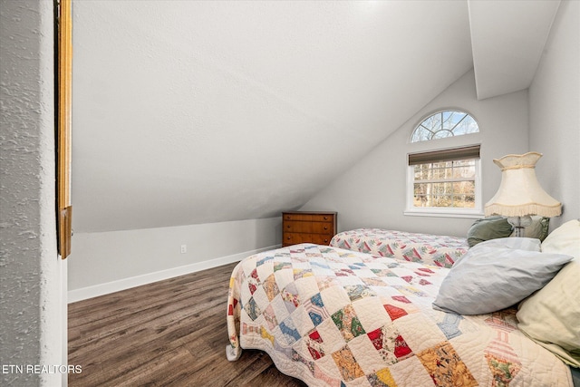 bedroom with dark wood-type flooring and vaulted ceiling