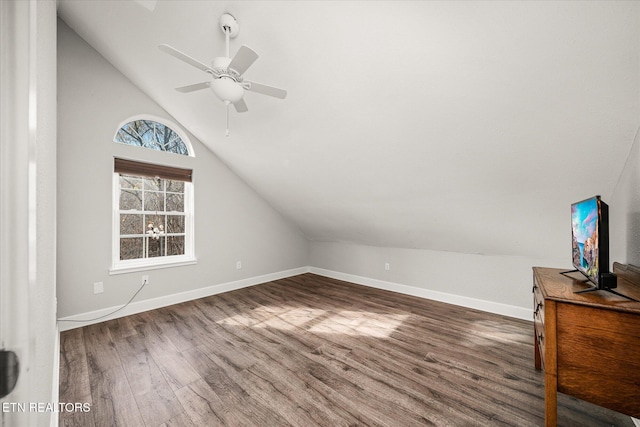 additional living space with ceiling fan, dark wood-type flooring, and vaulted ceiling