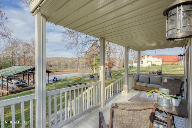 wooden terrace featuring a lawn, an outdoor living space, a water view, and a carport