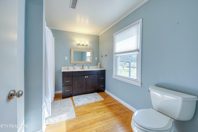 bathroom featuring hardwood / wood-style floors, vanity, toilet, and ornamental molding