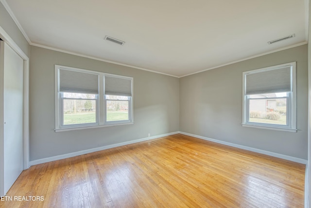 empty room with light hardwood / wood-style flooring and ornamental molding