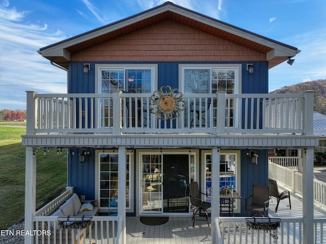 back of house with a balcony and a deck