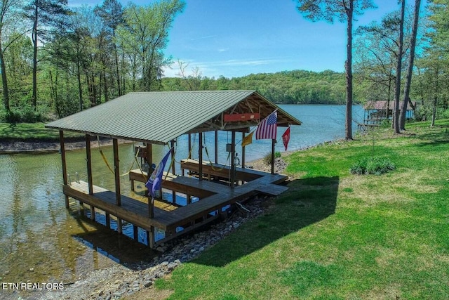 dock area featuring a lawn and a water view