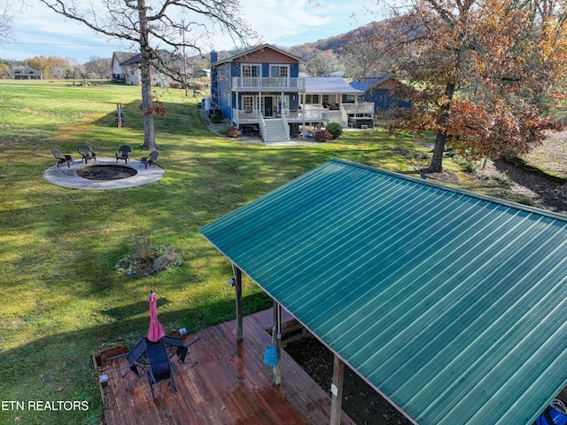 view of pool featuring a yard, a deck, and an outdoor fire pit