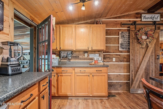 kitchen with wood walls, wood ceiling, light hardwood / wood-style flooring, and vaulted ceiling