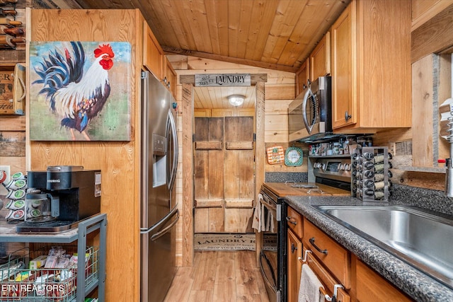 kitchen with wood walls, light hardwood / wood-style flooring, vaulted ceiling, appliances with stainless steel finishes, and wood ceiling