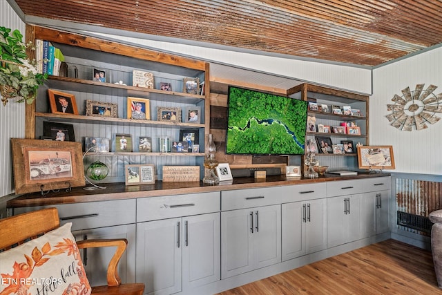 bar with light hardwood / wood-style floors and wood walls