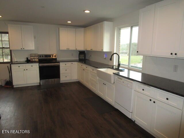 kitchen with dark wood-type flooring, white dishwasher, white cabinets, electric stove, and sink