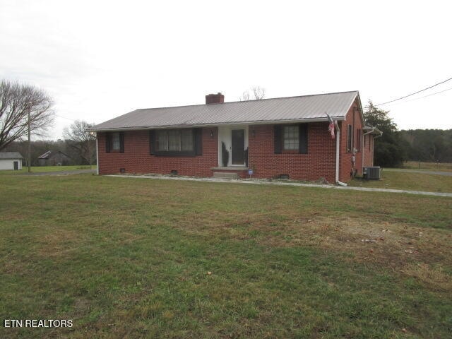 ranch-style house with central AC and a front yard