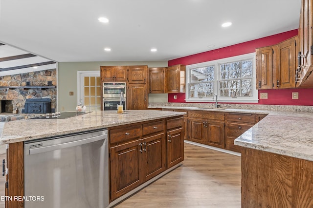 kitchen featuring a center island, light stone counters, sink, and appliances with stainless steel finishes