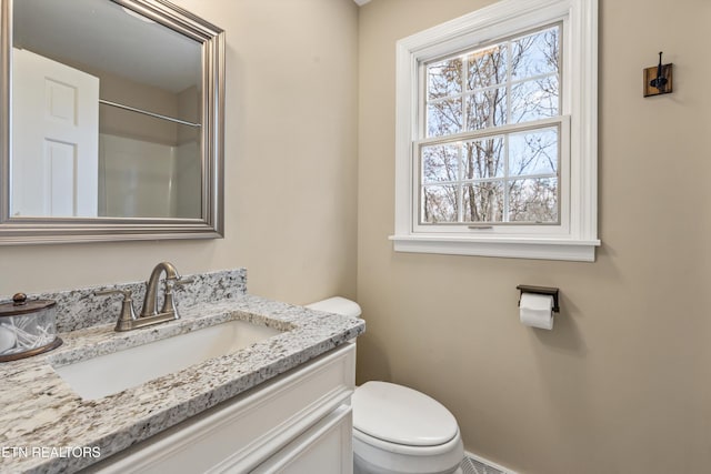 bathroom featuring a shower, vanity, and toilet