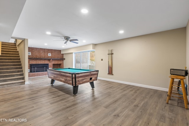 rec room with ceiling fan, light wood-type flooring, a fireplace, and billiards