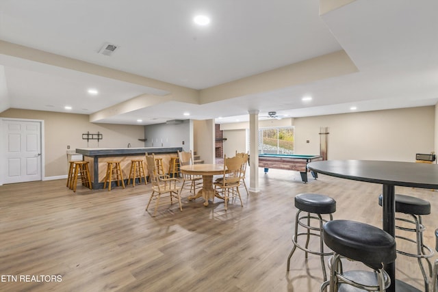 dining area featuring light hardwood / wood-style floors, bar, and billiards