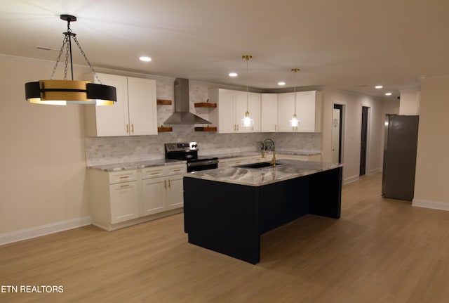 kitchen featuring white cabinetry, stainless steel appliances, wall chimney range hood, an island with sink, and light hardwood / wood-style floors