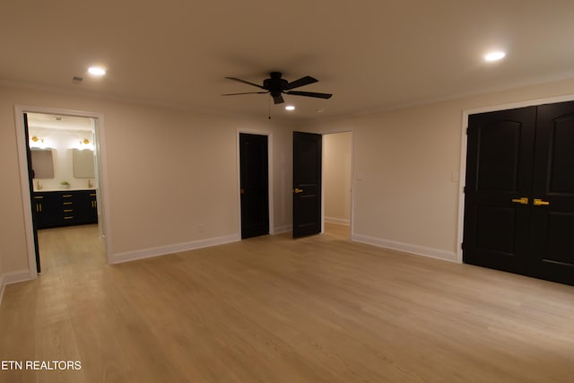 unfurnished bedroom featuring light wood-type flooring, connected bathroom, ceiling fan, and crown molding