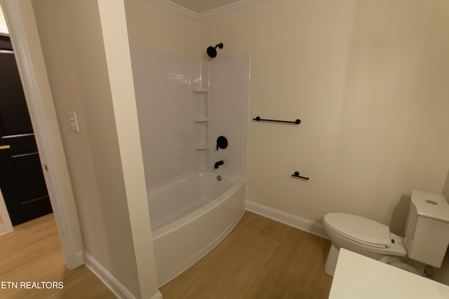 bathroom with wood-type flooring, toilet, tiled shower / bath, and crown molding