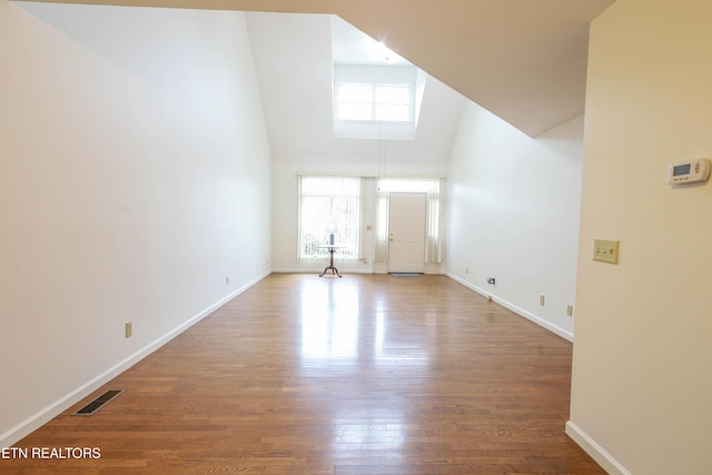 interior space featuring wood-type flooring and high vaulted ceiling