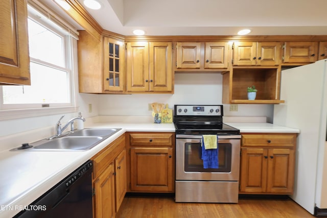 kitchen with dishwasher, sink, stainless steel electric range oven, white fridge, and light hardwood / wood-style floors