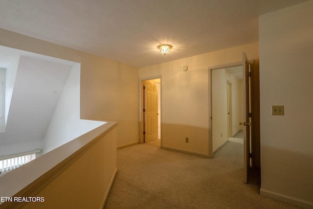 hallway featuring light colored carpet