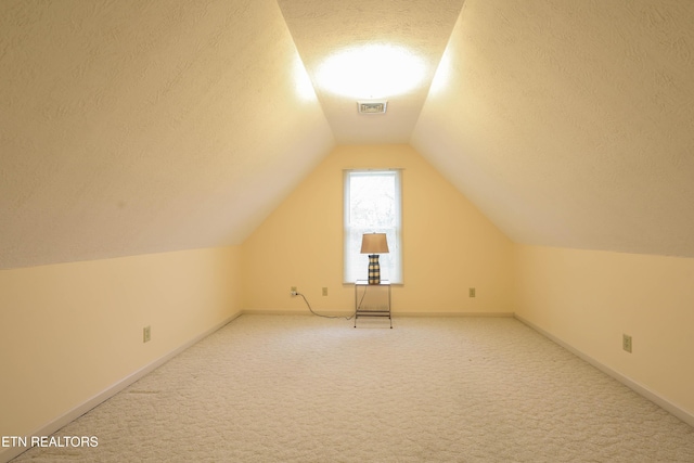 bonus room featuring a textured ceiling, carpet floors, and vaulted ceiling