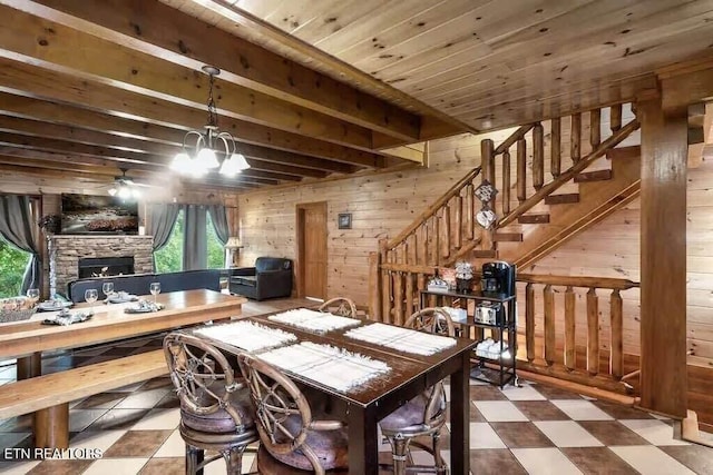 dining space with wooden walls, wood ceiling, and ceiling fan with notable chandelier