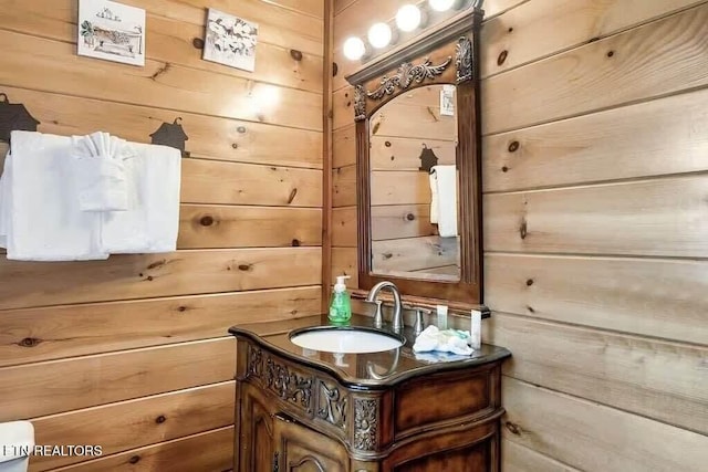 bathroom with vanity and wood walls