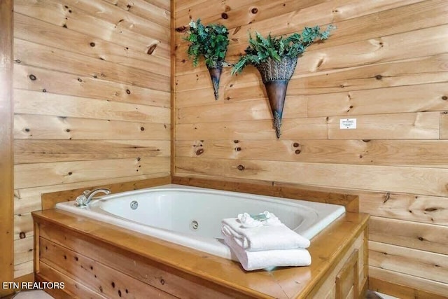 bathroom featuring a bath and wooden walls