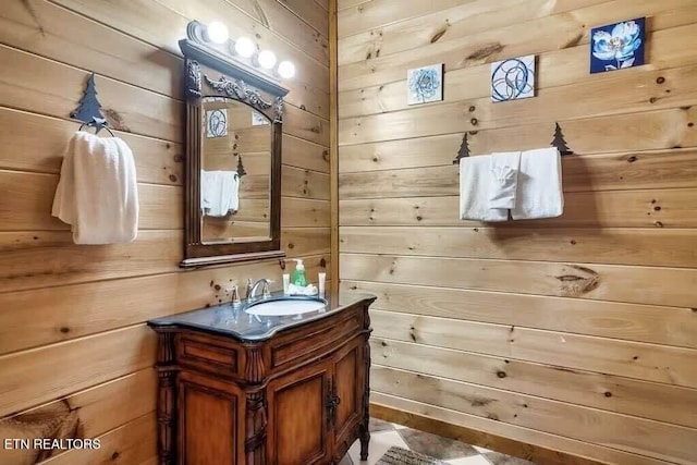 bathroom featuring vanity and wood walls