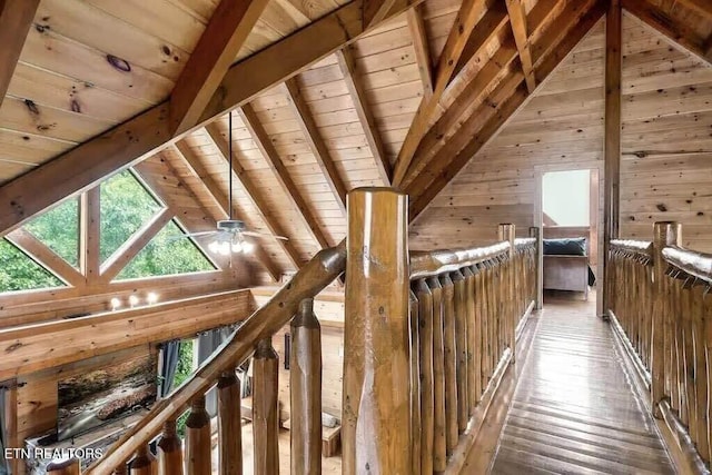 interior space featuring lofted ceiling with beams, hardwood / wood-style flooring, wooden walls, and wood ceiling