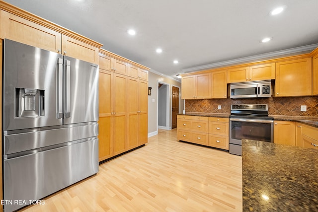 kitchen with tasteful backsplash, light hardwood / wood-style floors, and appliances with stainless steel finishes