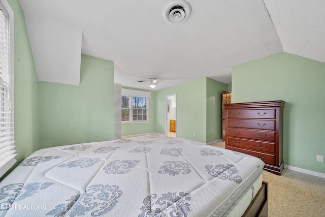 bedroom featuring ensuite bathroom, vaulted ceiling, and carpet