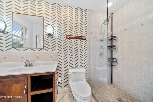 bathroom featuring tasteful backsplash, vanity, tiled shower, toilet, and tile patterned floors