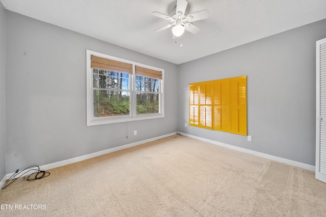 carpeted spare room with ceiling fan and a textured ceiling