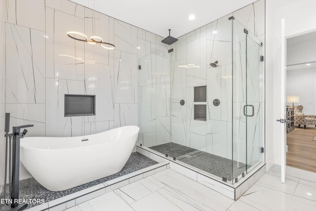 bathroom with tile walls and independent shower and bath