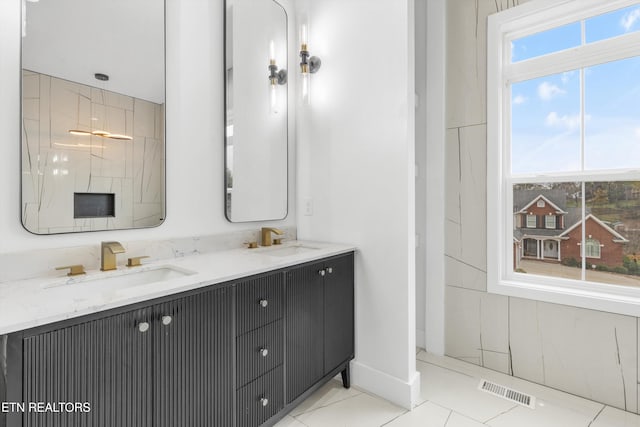 bathroom with tile patterned floors, a wealth of natural light, and vanity