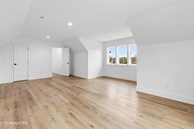 additional living space featuring light hardwood / wood-style flooring and lofted ceiling