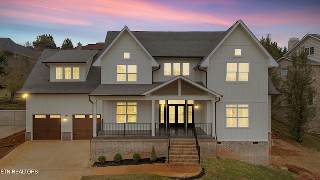 back house at dusk with french doors, a porch, and a garage