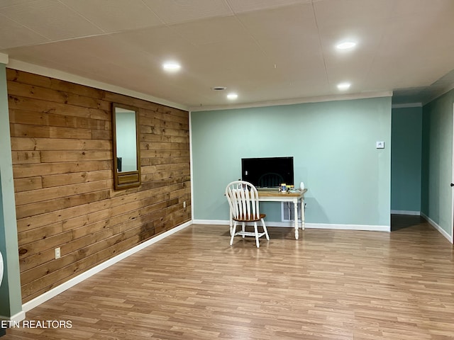 office area with wood walls, light hardwood / wood-style flooring, and ornamental molding