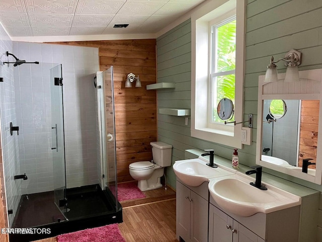 bathroom with wooden walls, vanity, an enclosed shower, and hardwood / wood-style flooring