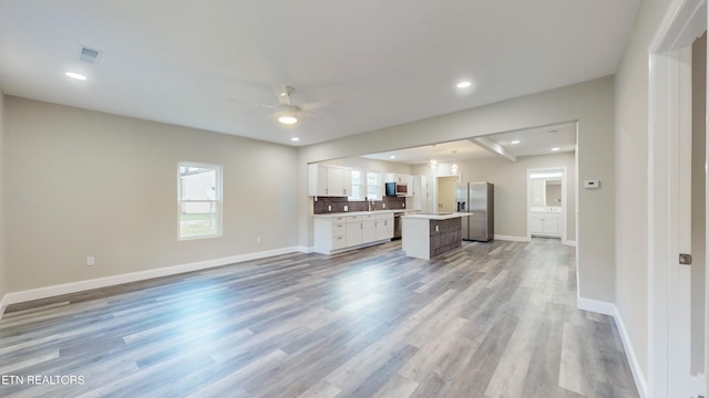 unfurnished living room featuring ceiling fan and light hardwood / wood-style flooring