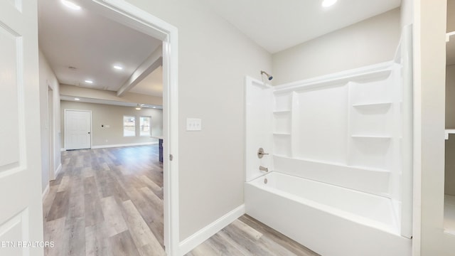 bathroom with bathing tub / shower combination and hardwood / wood-style flooring