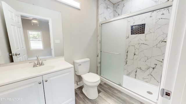 bathroom featuring vanity, hardwood / wood-style flooring, toilet, and an enclosed shower