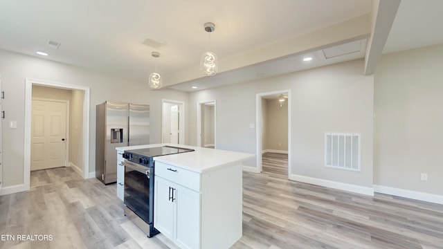 kitchen with hanging light fixtures, a kitchen island, appliances with stainless steel finishes, light hardwood / wood-style floors, and white cabinetry