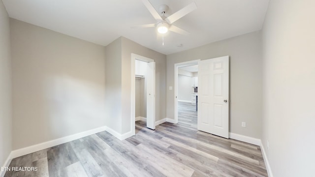 unfurnished bedroom with ceiling fan, light wood-type flooring, and a closet