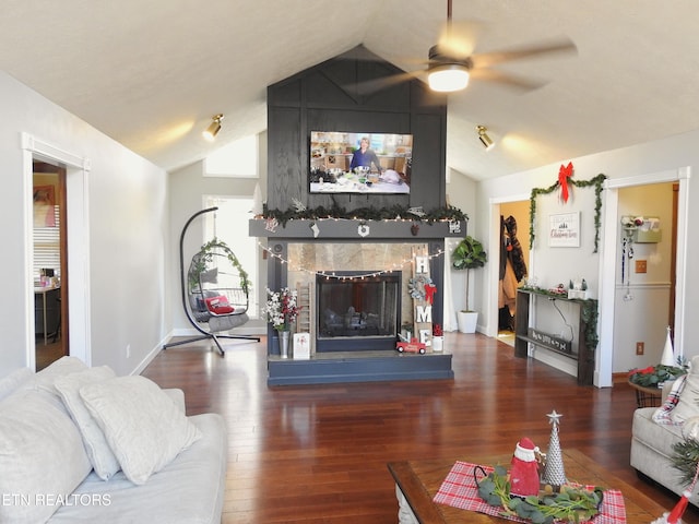 living room featuring a tiled fireplace, ceiling fan, dark wood-type flooring, and lofted ceiling