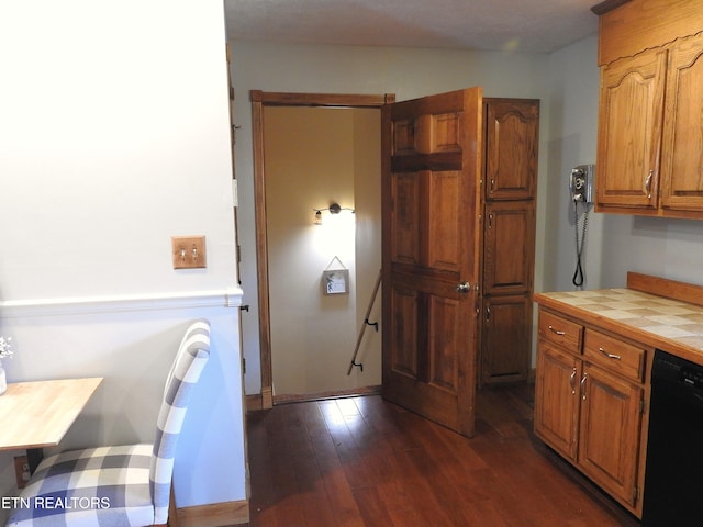 kitchen featuring tile countertops, dishwasher, and dark hardwood / wood-style floors