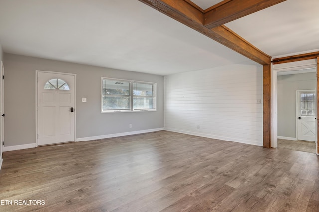 entrance foyer featuring hardwood / wood-style floors, plenty of natural light, and beam ceiling