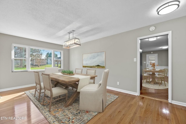 dining area featuring light hardwood / wood-style flooring and a textured ceiling