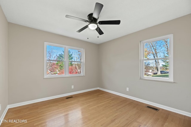 empty room featuring light wood-type flooring, a wealth of natural light, and ceiling fan